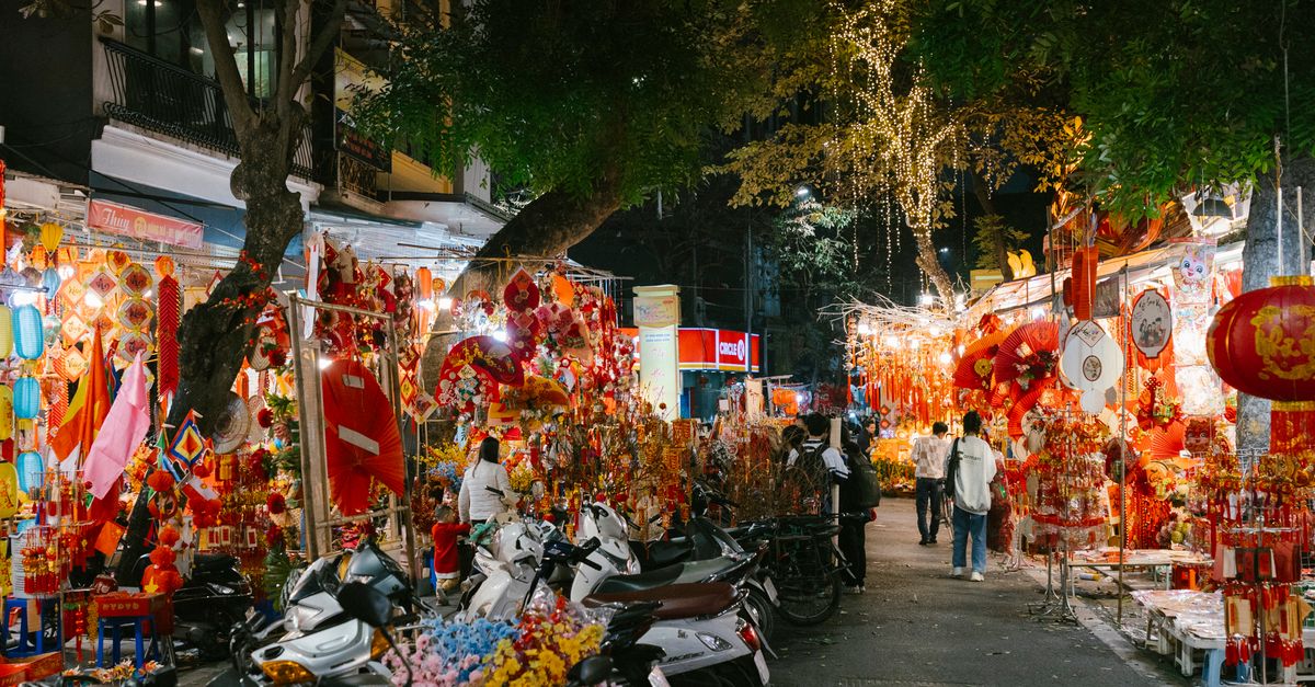 Hanoi Ho Central Market night scene with glowing lanterns and crowded stalls