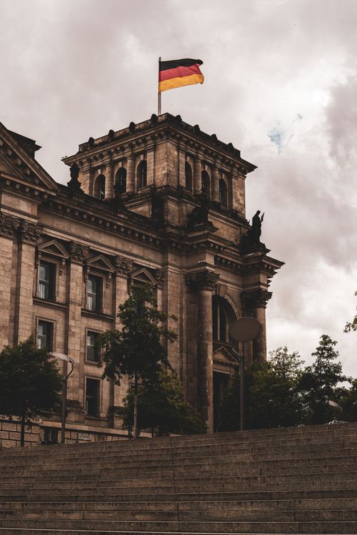 Free View of the historic Reichstag building in Berlin, Germany, featuring Renaissance architecture and the German flag waving above. Stock Photo