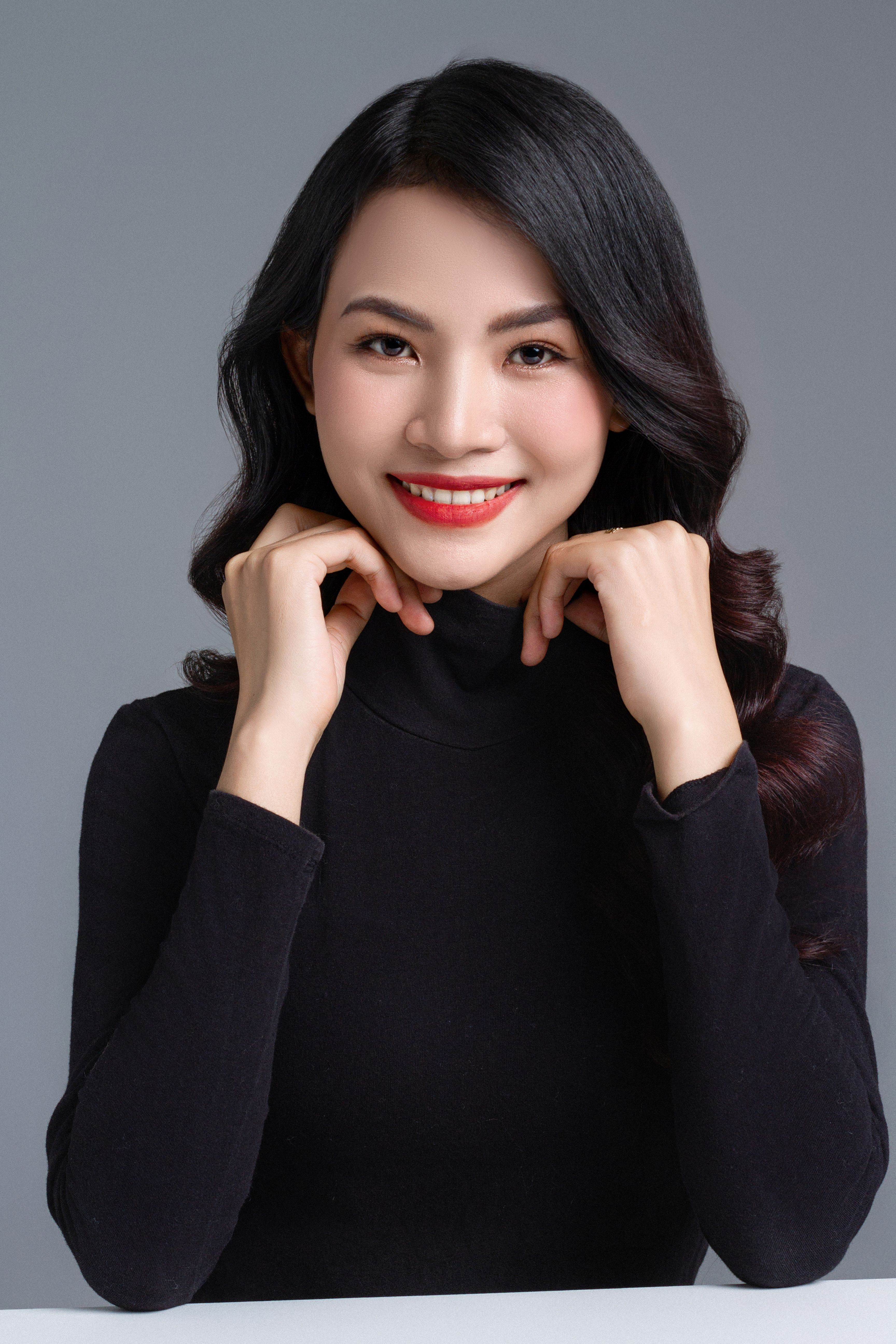Beautiful portrait of a smiling woman in a stylish black outfit, radiating confidence and warmth.