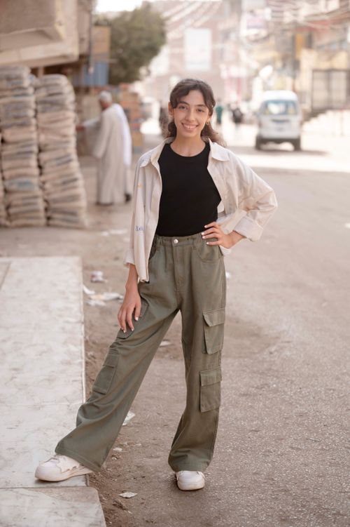 Free Fashionable young woman smiling in a city street, posing in style. Stock Photo