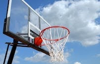 晴朗的蓝天下，篮球筐和篮板映衬出户外运动的精髓