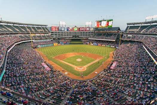 Aerial view of a lively baseball game at the iconic Globe Life Park filled with cheering fans.