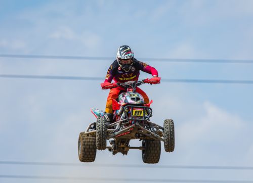 Free A quad bike rider performs a thrilling jump during an extreme sports race. Stock Photo
