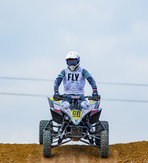 Free A quad bike rider wearing a helmet in action on a dirt track, showcasing adventure and excitement. Stock Photo