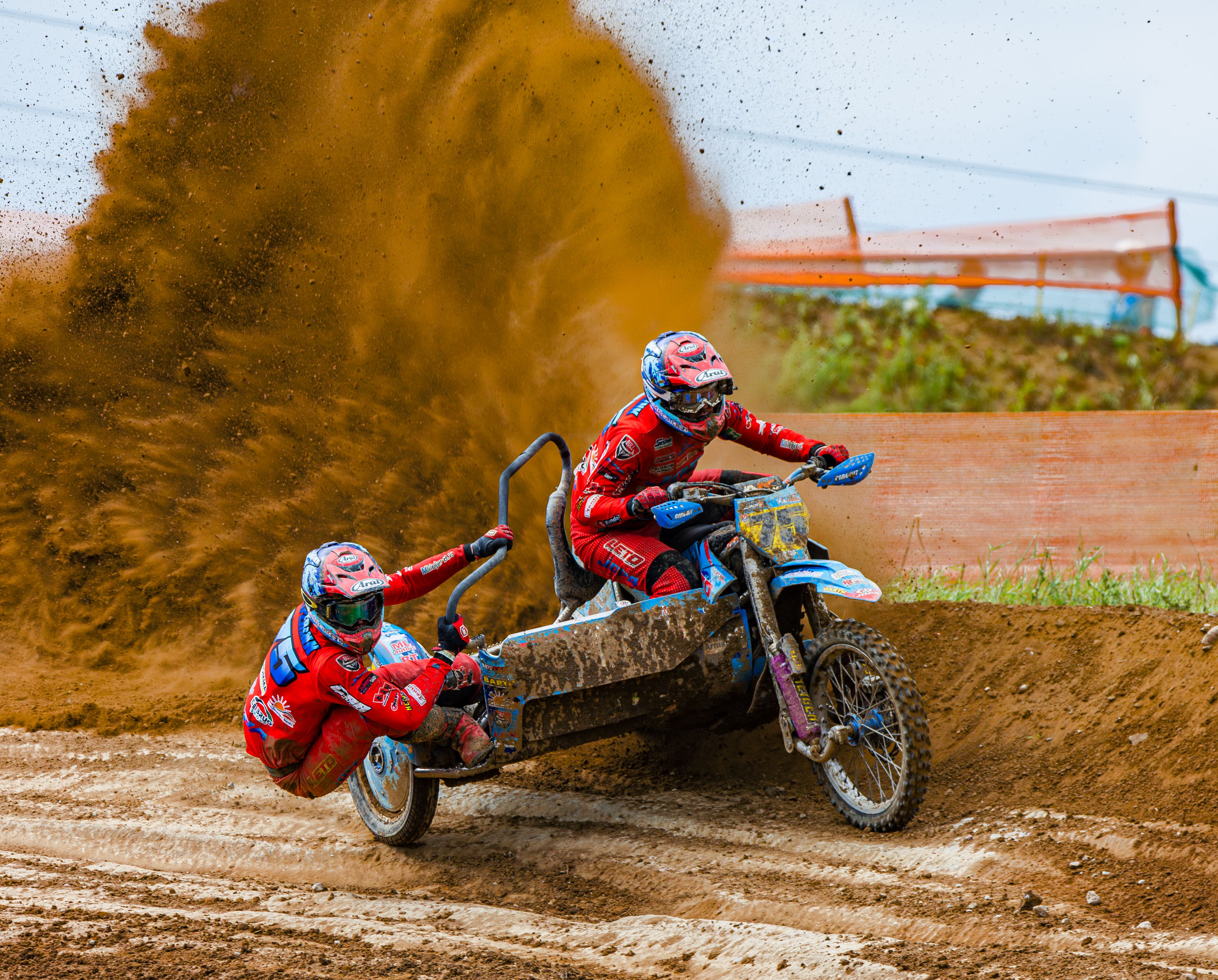 Two people riding dirt bikes down a dirt track · Free Stock Photo
