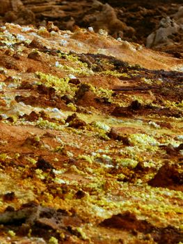 Vivid sulfur deposits on a rocky surface in Ethiopia's geothermal landscape.
