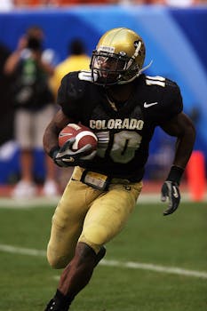 Dynamic action shot of an American football player running on the field during a game.