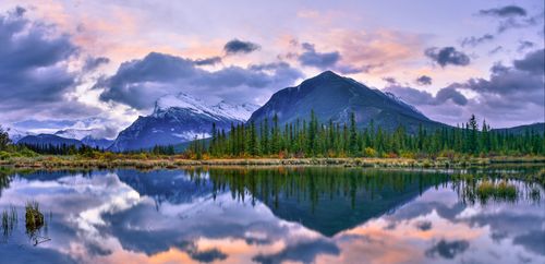 Free Breathtaking sunset over a lake reflecting mountains and forests in Banff, Canada. Stock Photo