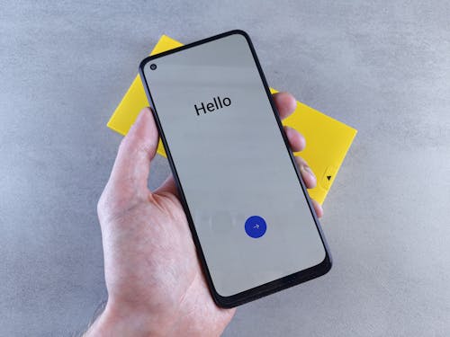 Free A person holding a smartphone with the word hello on it Stock Photo