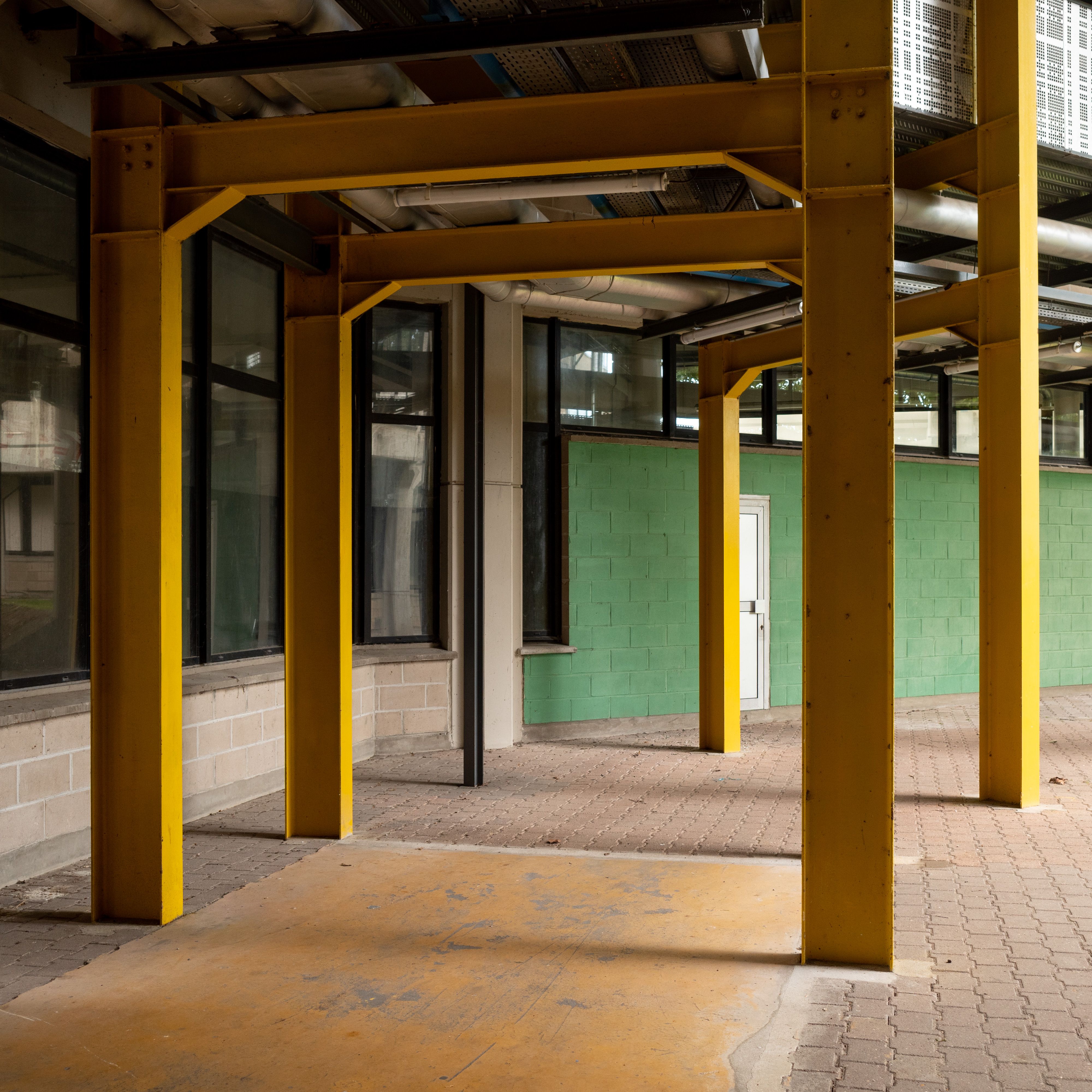 Urban architecture featuring yellow steel beams in a modern industrial setting.