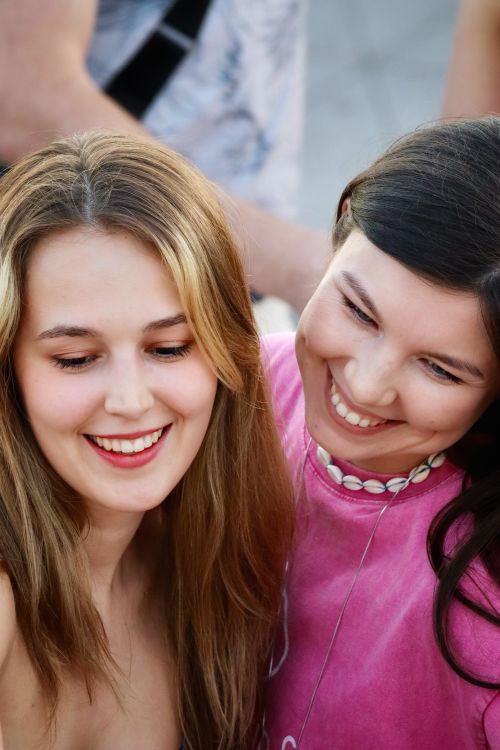 Free Two young women share a joyful moment while smiling together outdoors. Stock Photo