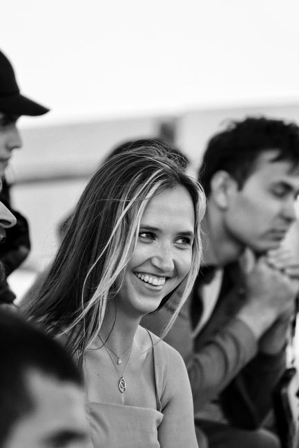 Black and white candid moment of friends enjoying and smiling together outdoors.