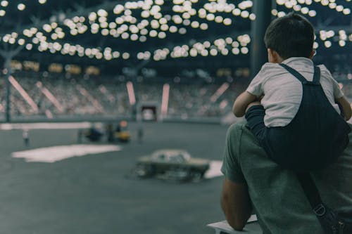 A man holding a child in front of a stadium