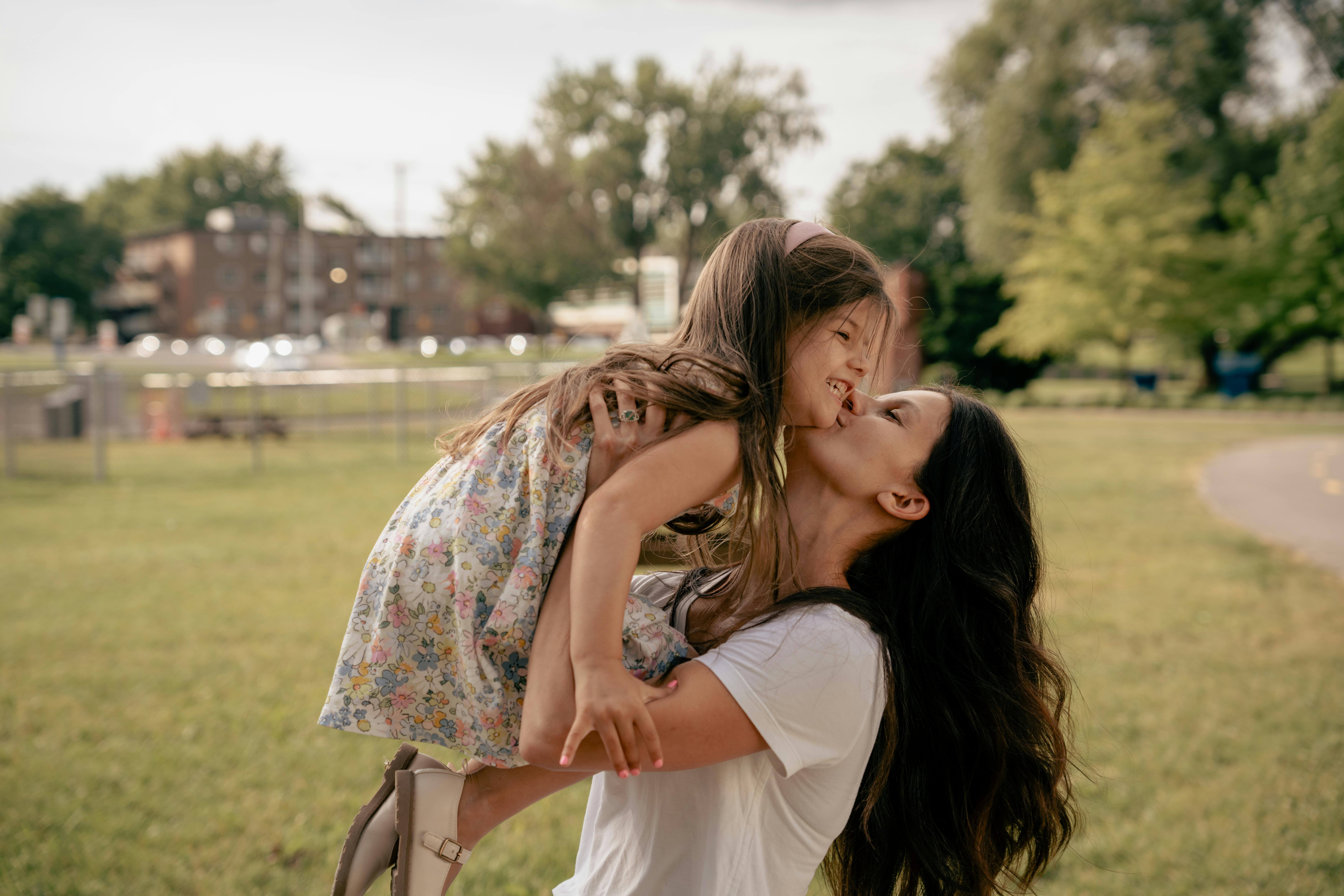 mother lifting and kissing daughter