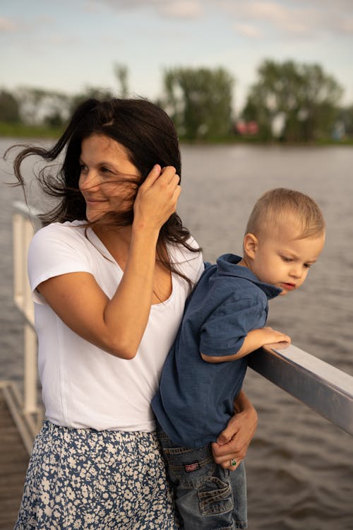 A woman and a child standing on a dock