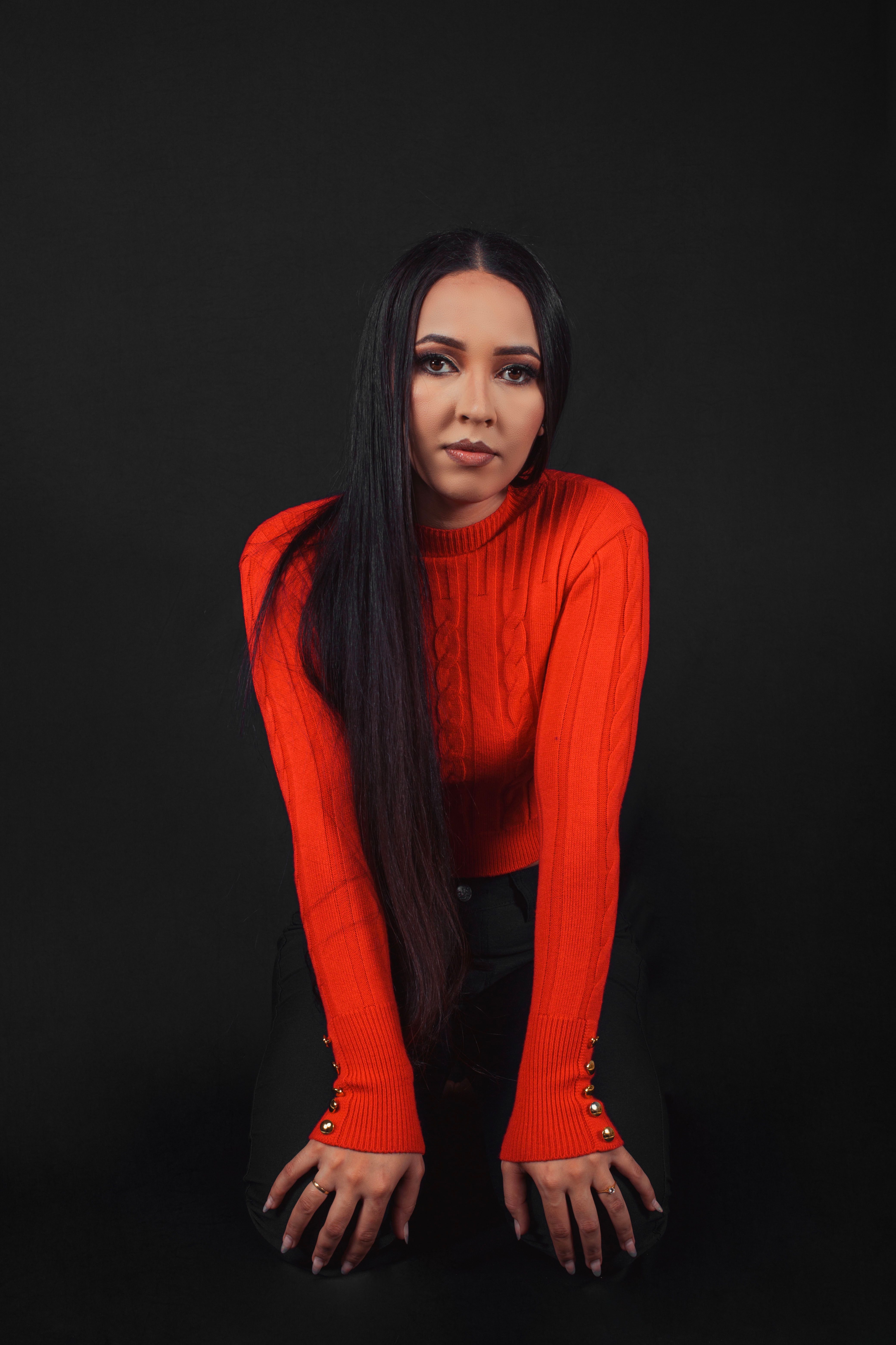 A woman in a red sweater posing for a photo · Free Stock Photo