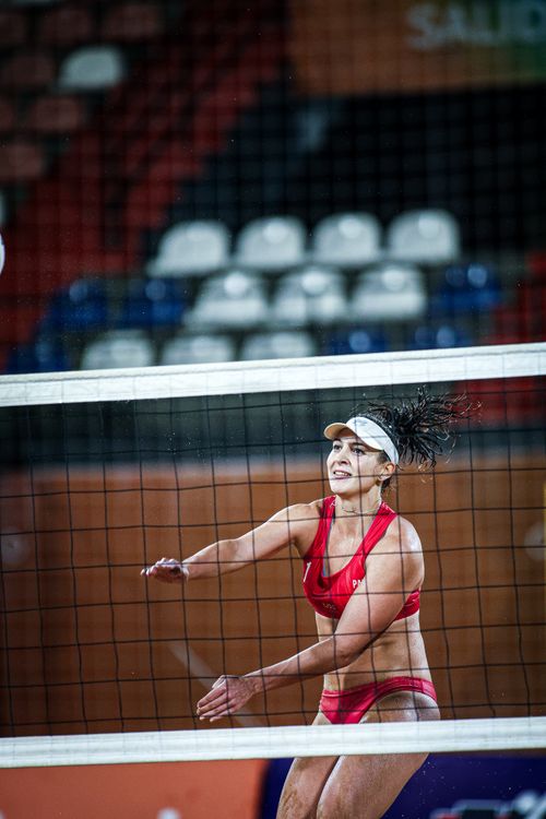 Free Female athlete playing beach volleyball, captured during a night game, showcasing determination and skill. Stock Photo