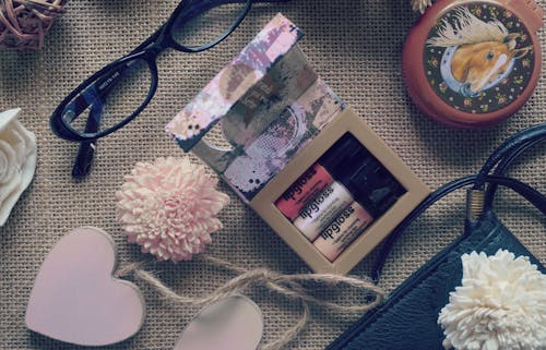 Free Flat Lay Photography of Lipstick , Eyeglasses and Heart Hanging Decor Stock Photo