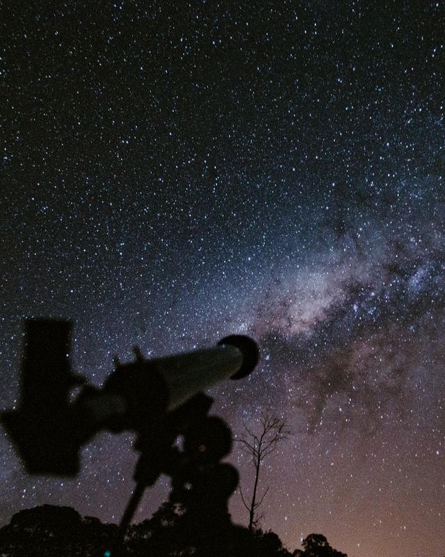 A telescope silhouetted against the band of the Milky Way