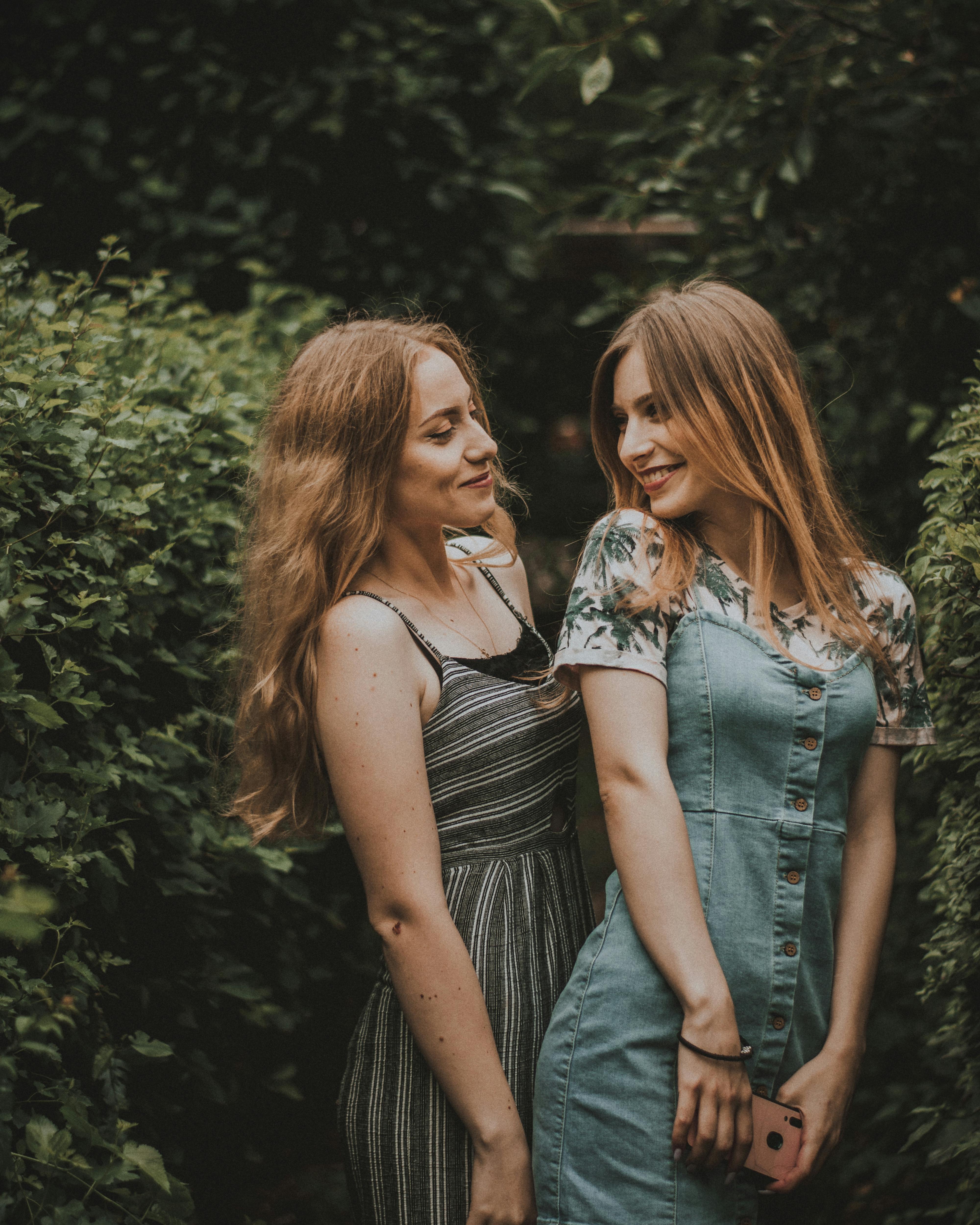 shallow focus photo of two women smiling near plants