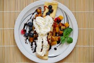 煎饼上铺着新鲜水果和奶油，放在时尚的盘子里，令人垂涎欲滴，非常适合享用甜蜜的早餐