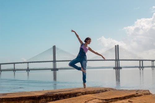 Free Photo of woman standing on rock formation doing yoga Stock Photo