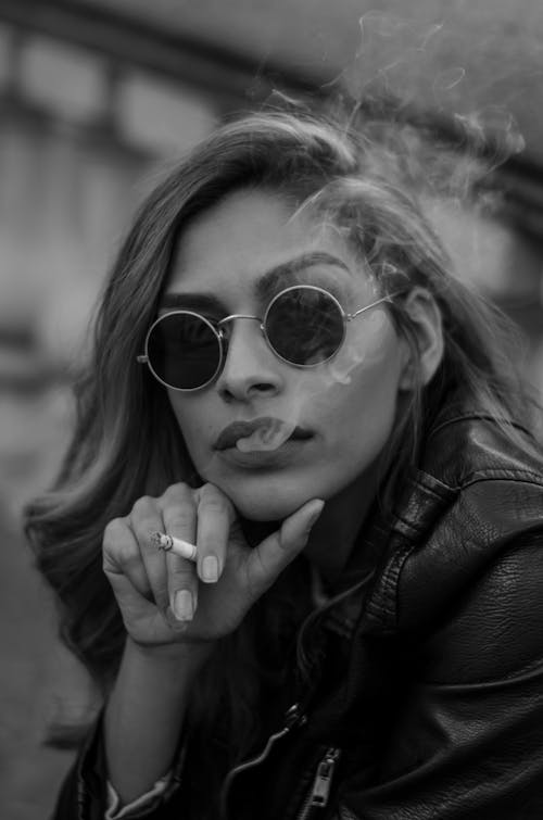 Gray scale portrait photo of woman smoking a cigarette 