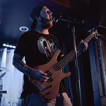 A captivating live performance with a bassist and singer passionately playing on stage.