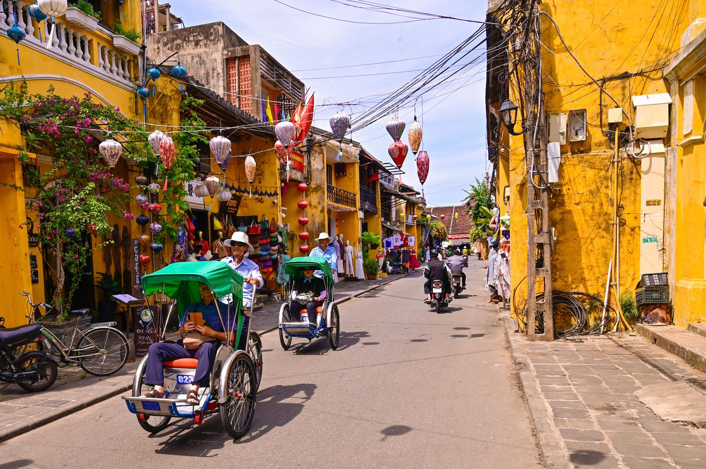 Farolillos colgados sobre una calle de Hoi An con ciclos esperando abajo, Vietnam
