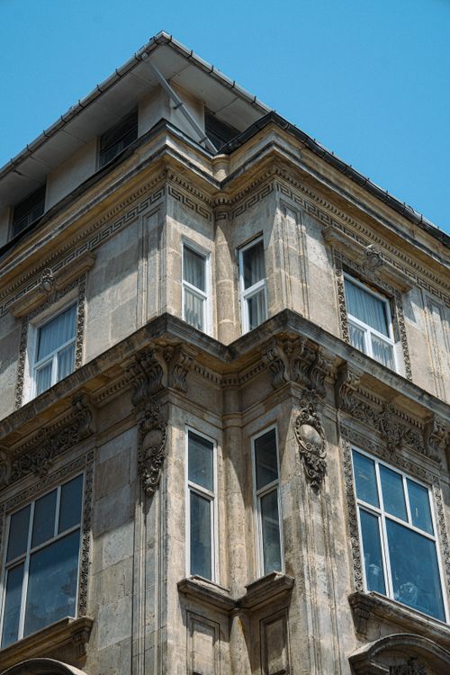 Free Low angle view of an ornate historic building facade featuring classical architecture in an urban setting. Stock Photo