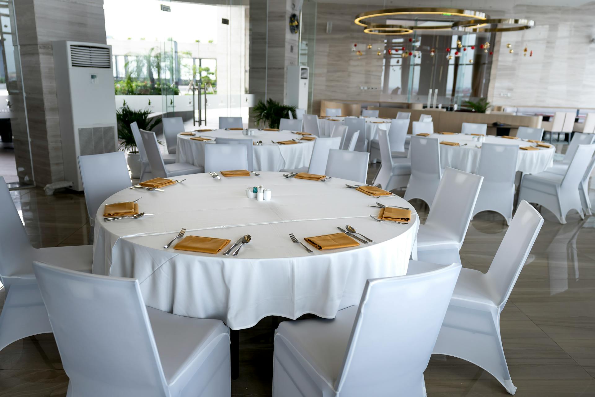 Spacious hotel dining room with round tables set for a luxury dining experience.