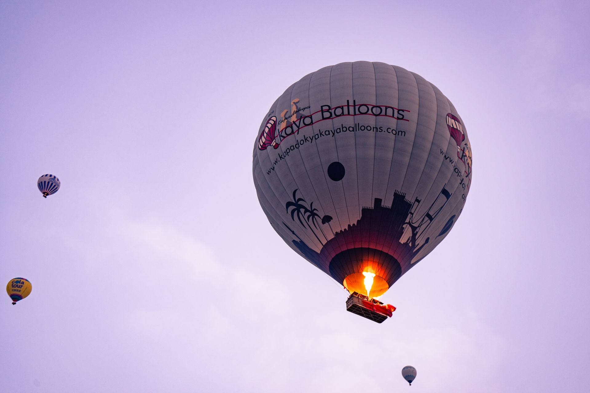 Captivating view of hot air balloons soaring over Göreme during sunrise, offering a serene adventure