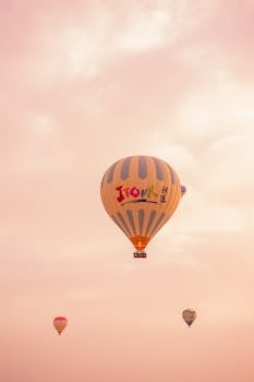 Majestic view of colorful hot air balloons soaring over Göreme at sunrise.
