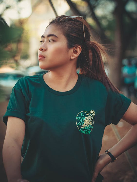 Selektywne Fokus Zdjęcie Kobiety W Zielonej Koszulce Pozowanie, Patrząc W Prawo