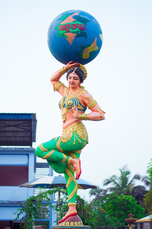 Free Vibrant statue of an Indian goddess holding a globe, adorned in traditional attire with intricate details. Stock Photo