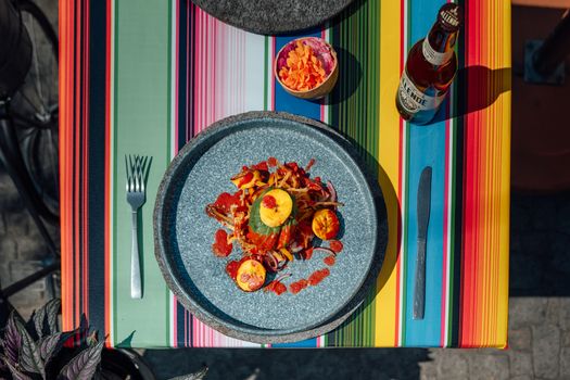 Vibrant Mexican dining experience featuring a plated meal and craft beer on a colorful table setting.