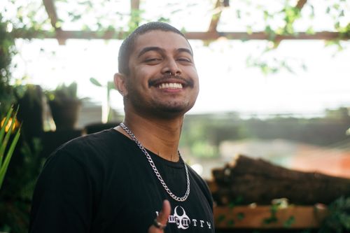 Free Cheerful man outdoors wearing a chain necklace and black t-shirt. Stock Photo
