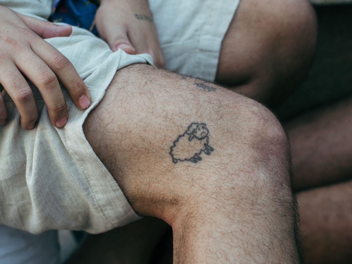 A healed black-and-grey rose tattoo with thorn stems.