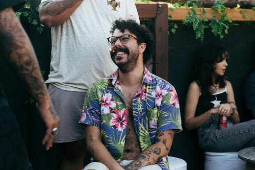 Free Man Sitting and Smiling in Colorful Shirt and Eyeglasses  Stock Photo