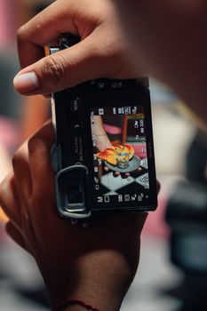 A close-up shot of a person taking a photo of a plated dish, showcasing food photography in action.