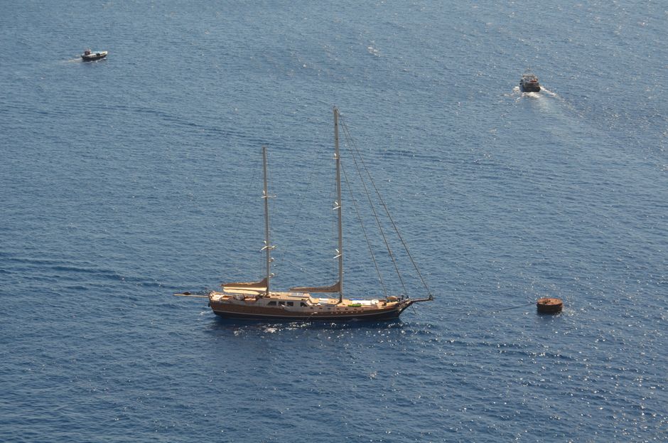 Outstanding Kefalonia Full Day Cruise and Guided Tour from Zakynthos Review 2026 - Aerial view of a yacht sailing in the blue waters near Fira, Greece, showcasing summer tranquility.