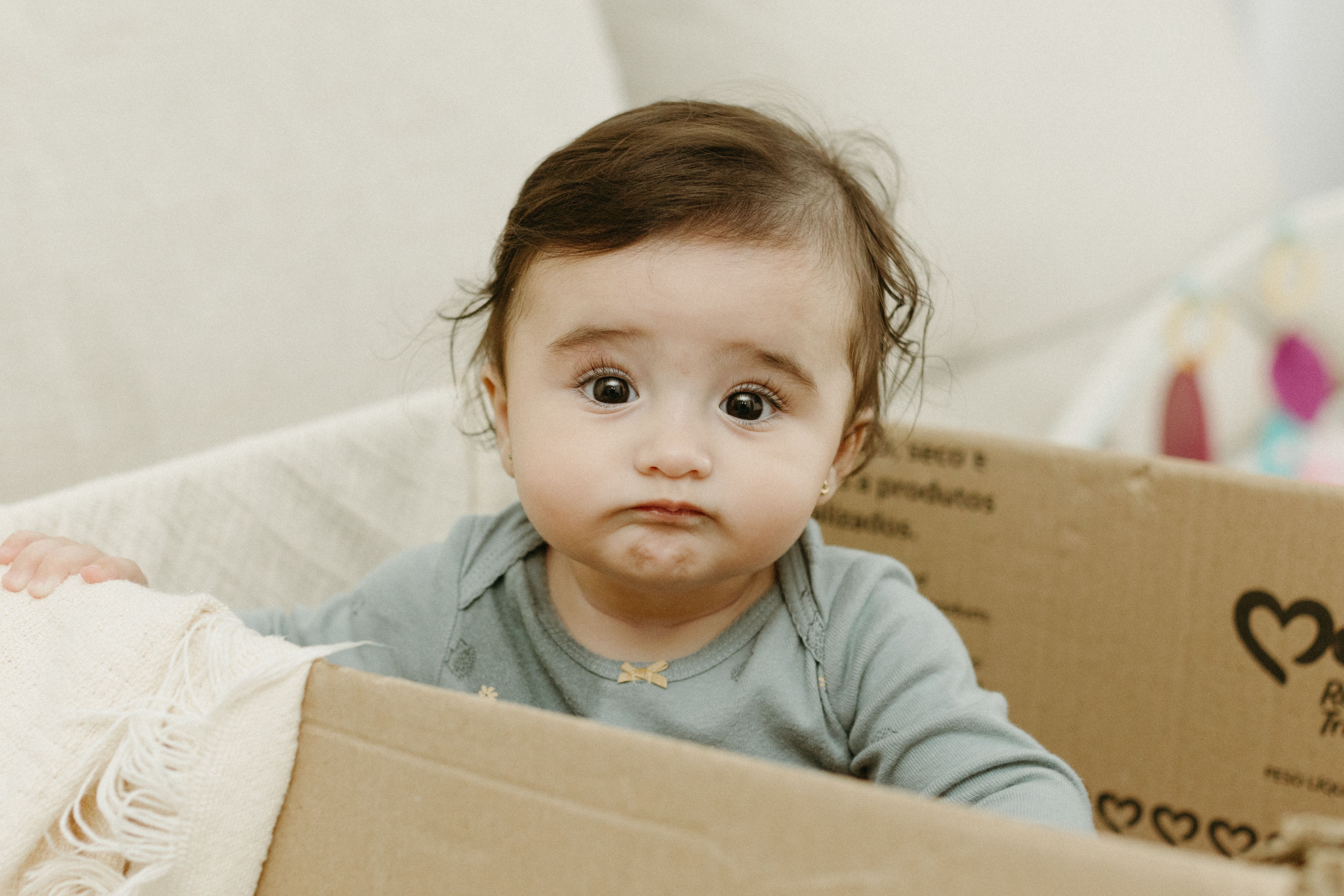 Confused Baby Sitting in Box · Free Stock Photo