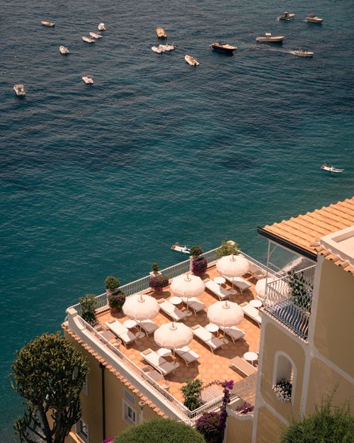 Free A stunning aerial view of a seaside terrace with elegant umbrellas and a vibrant sea backdrop. Stock Photo