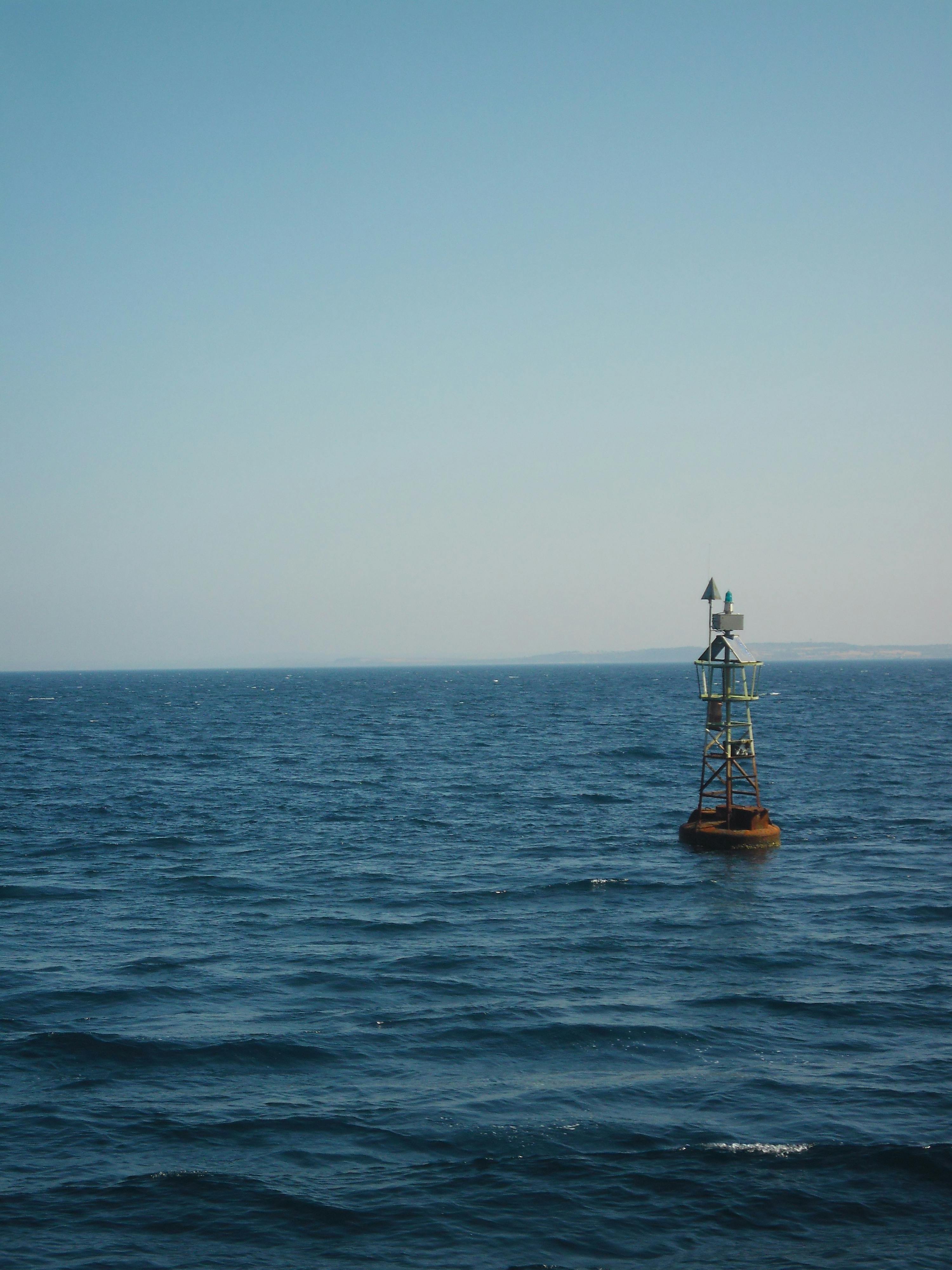A solitary navigation buoy floating in the clear blue Aegean Sea near Bozcaada, Türkiye.