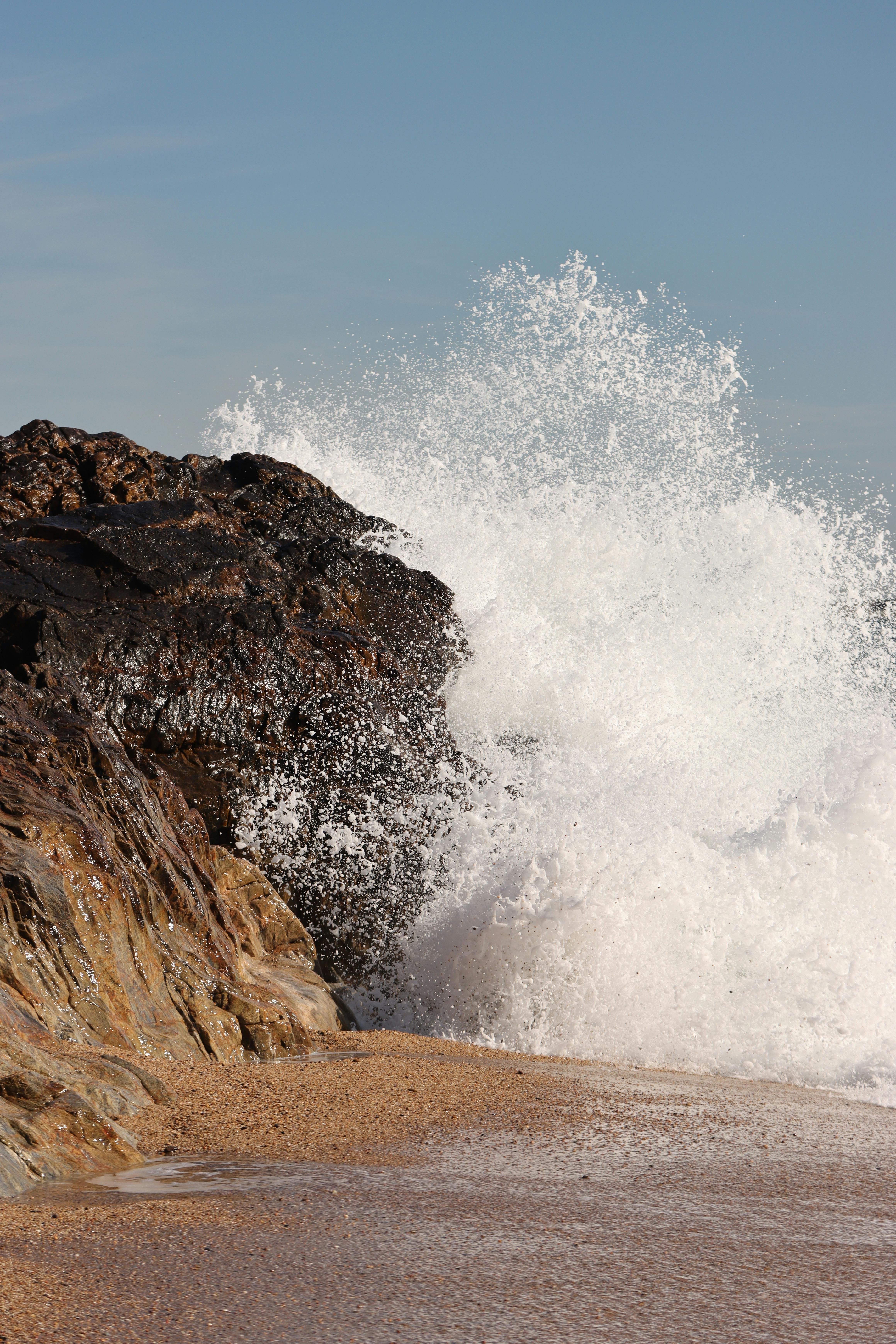 Dramatic ocean waves crash against rocks on the Porto, Portugal coast.