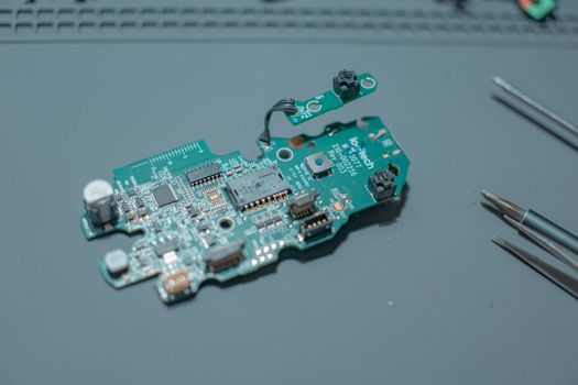 Detailed view of a circuit board with electronic components and tools.