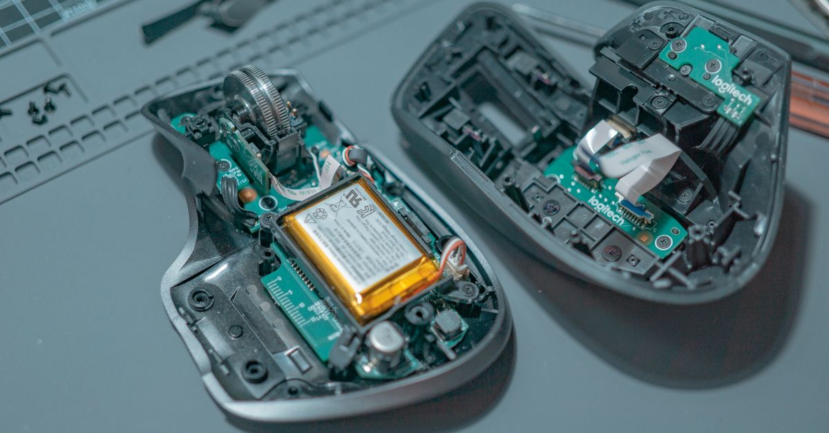 Close-up of a disassembled computer mouse revealing internal circuit boards and components.