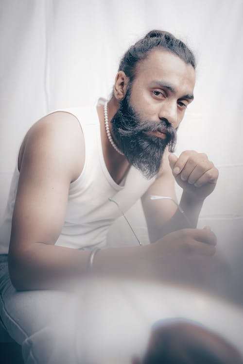 Free A man with a beard and long hair is sitting on a toilet Stock Photo