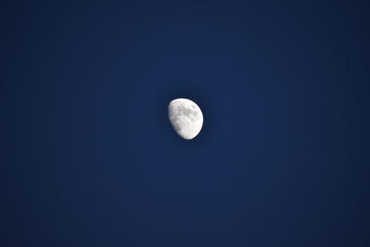 A stunning view of the moon against a clear night sky, showcasing its craters.