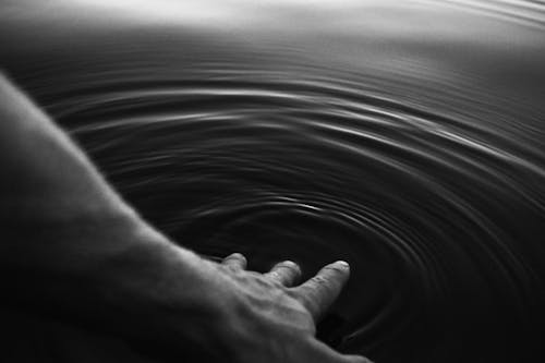 Foto De Persona Tocando Un Cuerpo De Agua